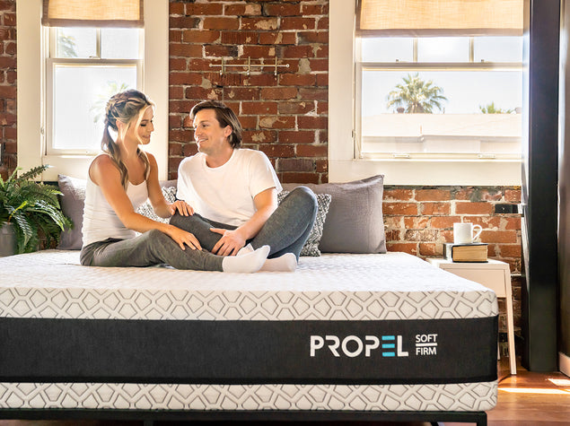 Couple Sitting on the Propel Dual-Sided Hybrid Mattress